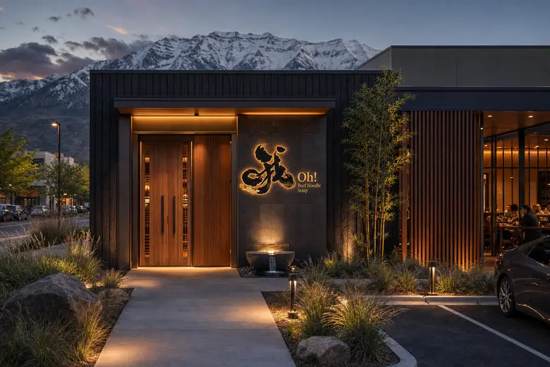 Rendering of an Oh! Beef Noodle Soup entrance at dusk: a tall wooden door beside a glowing Oh! logo, a small stone fountain and bamboo.