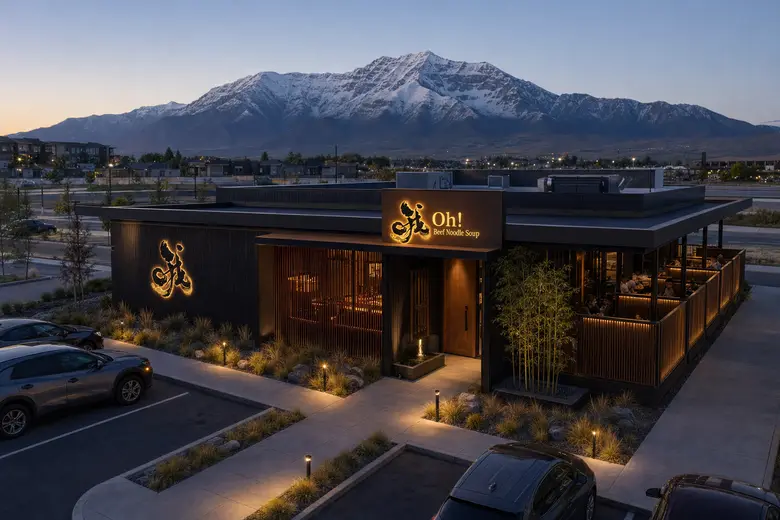 Rendering of the planned Oh! Beef Noodle Soup at Sky View in Lehi at dusk: a dark wood building with a glowing Oh! sign, a covered patio and Mount Timpanogos behind it.